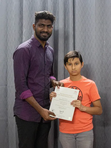 A proud moment for our student receiving his grade exam certificate. We celebrate every milestone, providing recognized certifications from boards like ABRSM and Trinity College London.