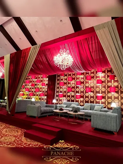 A luxurious lounge area for the after-party, created with rich red velvet drapes, modern sage green sofas, and crystal chandeliers.
