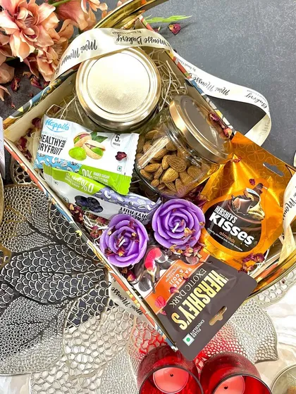 This is my "All in One" Diwali hamper. It's packed with a variety of treats including dry fruit jars, chocolates, and festive candles, making it a truly impressive gift.