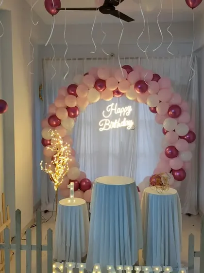A minimalist and romantic home setup with a pink and white balloon ring and sheer curtain backdrop.