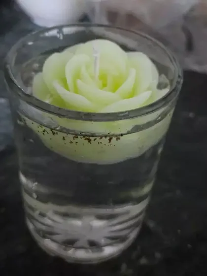 Another view of a rose candle floating in a glass of water. It's a simple way to add a touch of beauty and light to any corner of your home.
