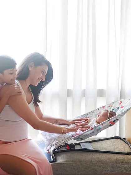 A sweet lifestyle moment at home. Big brother watches lovingly as his mother tends to the new baby, Misha, in her favorite rocker.