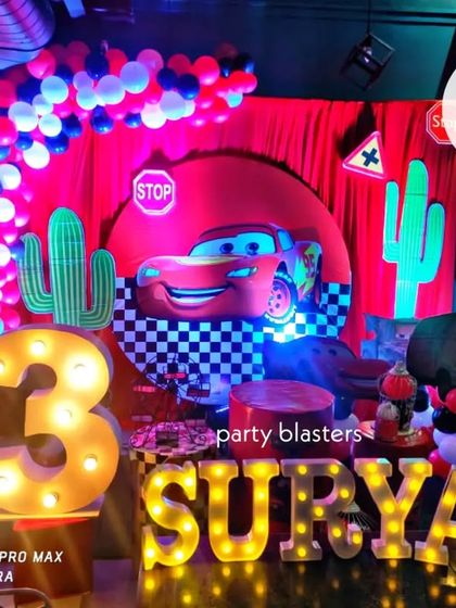Vroom! A Cars themed party for Surya's 3rd birthday, complete with a Lightning McQueen backdrop, cactus cutouts, and illuminated letters for the name and age.