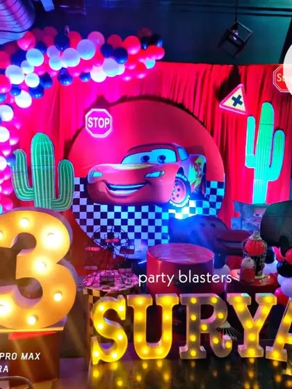 Vroom! A Cars themed party for Surya's 3rd birthday, complete with a Lightning McQueen backdrop, cactus cutouts, and illuminated letters for the name and age.