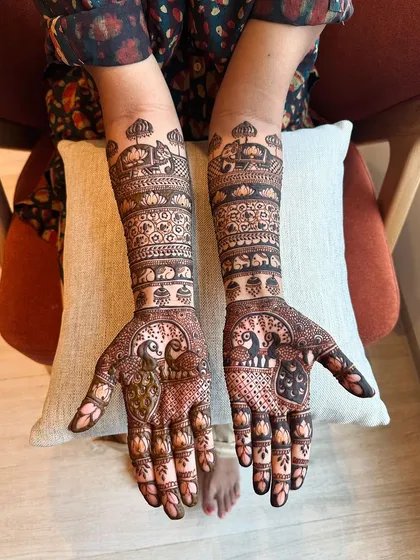 This design features a pair of peacocks on each palm, symbolizing love and partnership, set against a backdrop of architectural and floral patterns.