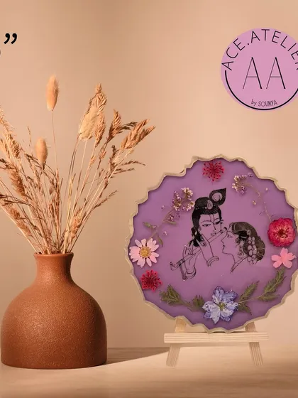 A 6-inch Radha Krishna frame in a soft lavender, with real flowers that complement the divine couple's image.