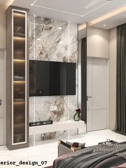 A bedroom TV unit featuring a tall, illuminated display niche beside the main marble-finish panel. This asymmetrical design adds visual interest and personalized display space.