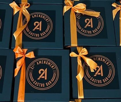 A close-up of the finished Halloween boxes, showing the custom logo and the vibrant satin ribbon that completes the look.