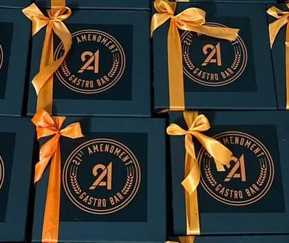 A close-up of the finished Halloween boxes, showing the custom logo and the vibrant satin ribbon that completes the look.