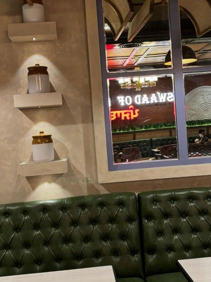 Our cozy green booth seating, with a view of the "Swaad of Punjab" neon sign. It's the best seat in the house.