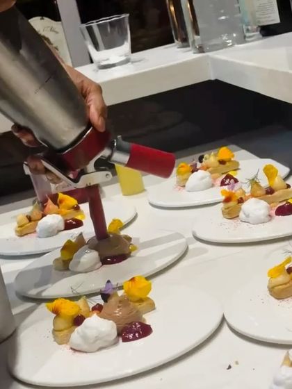 Using a siphon to add a light, airy foam to a dessert. This modern technique adds a unique texture and dimension to the dish.