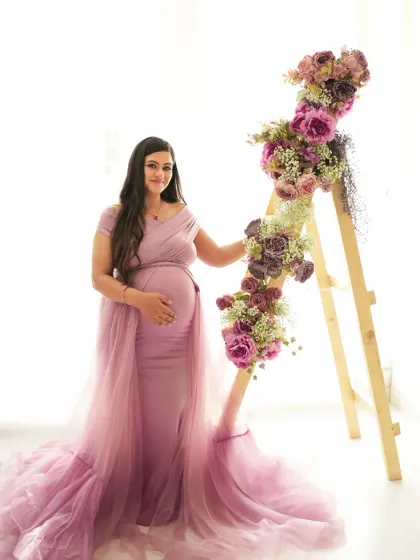 A lovely solo portrait in a dusty rose gown. The floral arrangement adds a soft, feminine touch to this beautiful studio maternity photo.