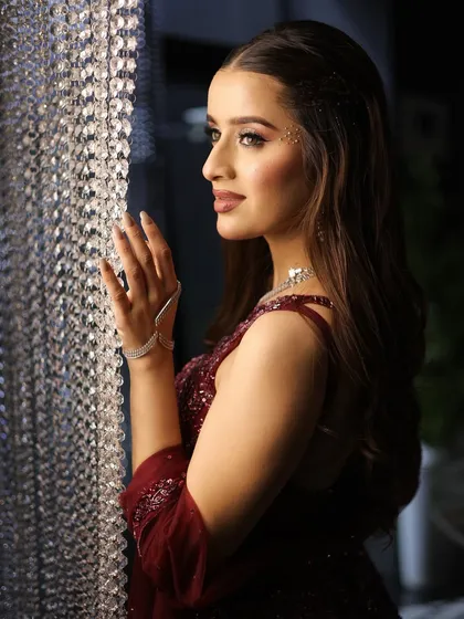 A profile shot capturing the allure of this cocktail look. The soft smokey eye and dewy skin look stunning against the dramatic lighting.