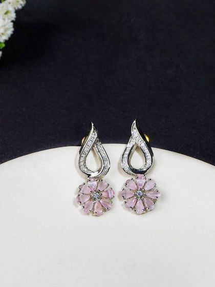 Silver and pink floral earrings shot against a contrasting black and white background. This composition makes the product stand out, ideal for e-commerce.