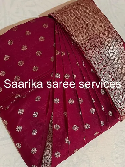 A magenta saree with delicate silver butis, neatly folded and ready for storage.