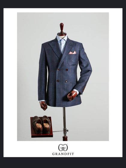 This blue double-breasted blazer showcases a softer construction, making it a versatile piece for smart-casual or formal events. The texture of the fabric adds a relaxed elegance.