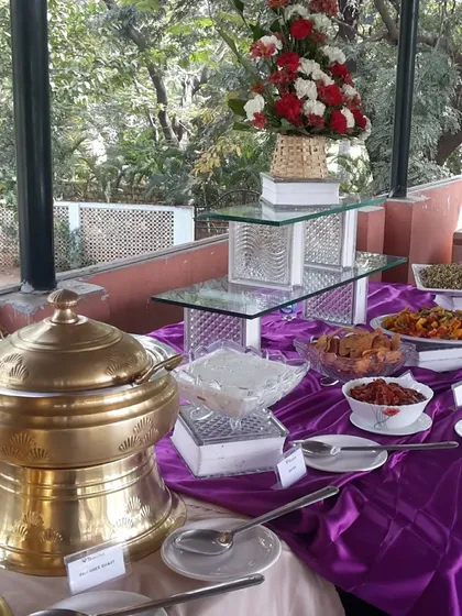 An elegant buffet arrangement with a purple and gold theme for a special celebration. The setup includes our ornate golden serving dishes and tiered glass stands for a touch of luxury.