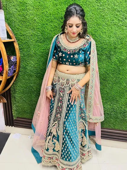 A rich teal velvet lehenga with intricate doli and baraat embroidery. This rental piece is perfect for a winter wedding function, offering both warmth and style.