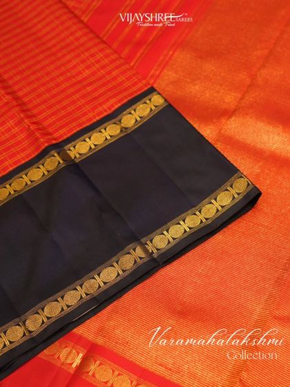 The contrast of the royal blue pallu against the red body, both framed by the unique Bentex border.