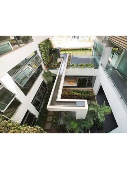 An aerial view of the central courtyard shows how the water channel navigates the different levels. This nature-integrated feature brings the sights and sounds of water into the core of the building, creating a tranquil oasis within the office environment.