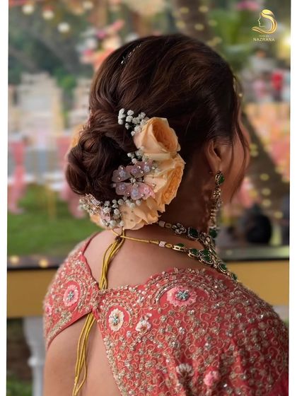 A side profile showcasing the elegant bun with peach roses and butterfly accessories.