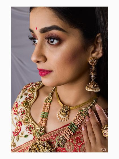 A detailed shot focusing on the bride's expressive eyes and the exquisite craftsmanship of her antique necklace and jhumkas.