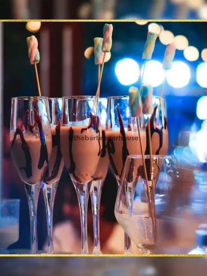 A close-up of our chocolate shakes, with rich syrup dripping down the glass and a colorful marshmallow skewer. It's a dessert in a glass.