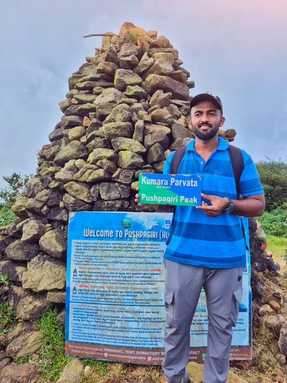 A full-length shot of a trekker at the Kumara Parvatha peak, one of the most challenging treks in the Western Ghats.