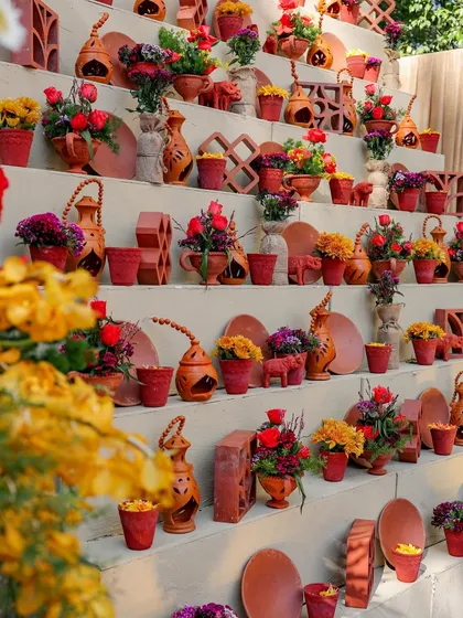 A tiered display of terracotta pottery and floral arrangements. This installation served as a beautiful decor piece, showcasing local craftsmanship and the event's core materials.