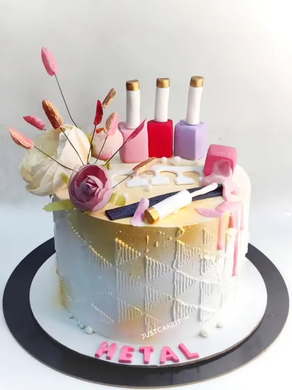 A chic cake for a nail artist, complete with edible nail polish bottles and nail art tools. The design has a stylish gold and white textured finish.
