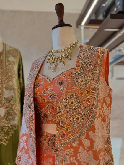 Carefully curated festive fits. This display pairs an earthy green kurta with a stunning brocade jacket set in peach and orange tones.