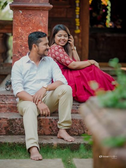 A candid moment of shared laughter on the steps of a temple. The couple's relaxed and happy interaction makes for a natural and beautiful pre-wedding photo.