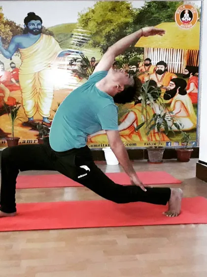 A student in Viparita Virabhadrasana (Reverse Warrior Pose). This posture builds strength in the legs while creating a beautiful side-body stretch, opening the space between the ribs.