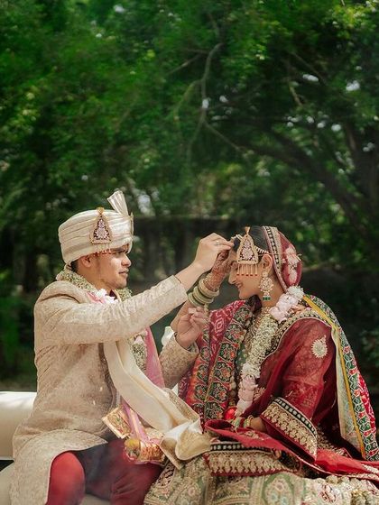 The groom places the 'sindoor' on the bride's forehead, a beautiful ritual symbolizing their new status as a married couple.