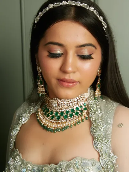 A gorgeous reception look with a diamond headband and emerald jewelry. Our students learn to style the complete look.