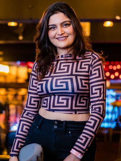 A guest posing in a patterned top.