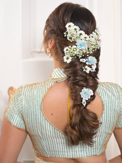 A mermaid braid is a stunning choice for a unique bridal look. I adorned this one with fresh baby's breath and light blue flowers to match the bride's pastel outfit.