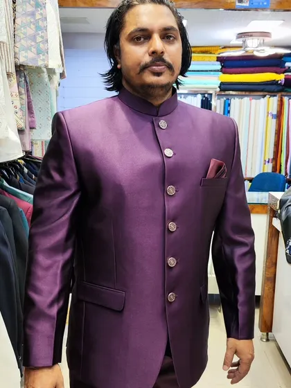 A client looking distinguished in a rich wine-colored Jodhpuri suit. The solid color and sharp tailoring create an eye-catching look that stands out at any event.