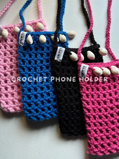 My crochet phone holders are perfect for concerts or Navratri nights. This netted design is decorated with cowrie shells for a boho, beachy vibe and comes in multiple bright colors.