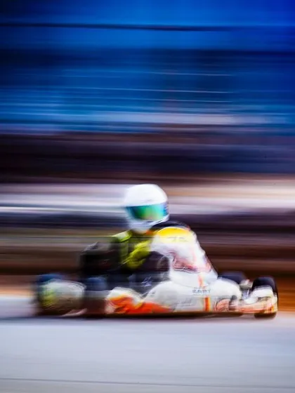 An artistic, high-speed panning shot capturing the essence of karting.