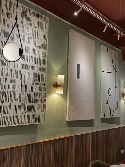An installation of three large 6ft x 3ft minimalist canvases at Sidewalk cafe. Each piece explores a different abstract concept using a simple black and white palette, creating a cohesive and stylish gallery wall.