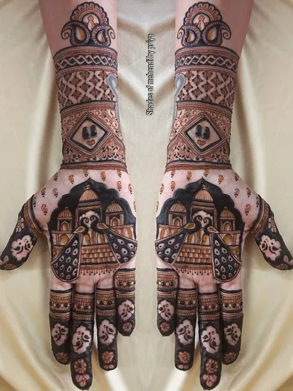 Symmetrical bridal mehendi for both hands, featuring majestic peacocks against an architectural backdrop. This design uses bold lines and filled spaces for a dramatic effect.