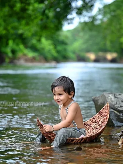A beautiful, calm portrait of the baby in the boat, surrounded by the lush green scenery.