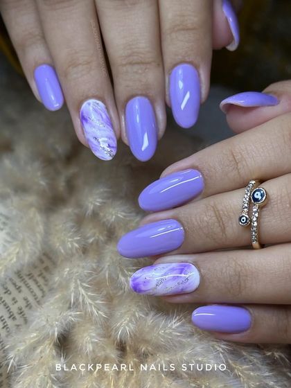 An elegant set featuring lilac polish with beautiful purple and white marble accents. This is a perfect combo for clients who want a stylish and artistic design.