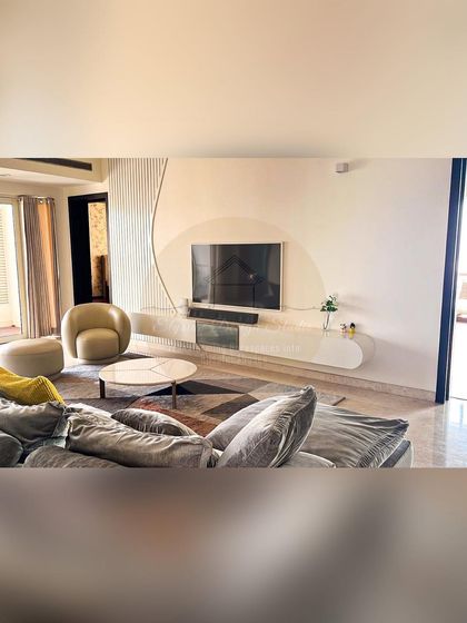 A minimalist living room in our Prestige White Meadows project. The space features a floating TV console, curved furniture, and a neutral color palette to create a sense of calm and sophistication.