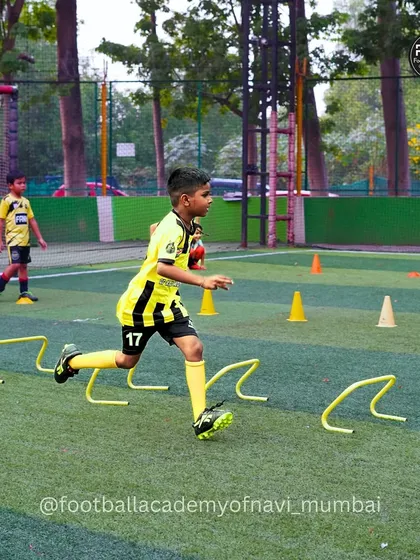 A young player demonstrates focus and precision while navigating an agility hurdle course during a training session.