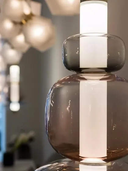 A close-up view of a Luna pendant, highlighting the rich, smoky color of the glass and its flawless, reflective surface.