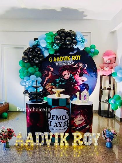 A Demon Slayer anime theme for a 10th birthday. We used a dark and dramatic color palette with a circular character backdrop, themed pedestals, and the birthday boy's name in light-up letters.