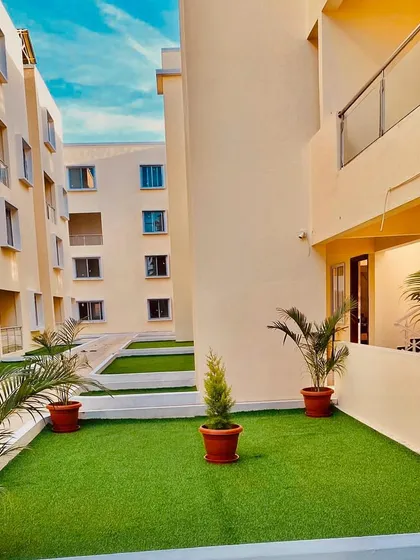 This apartment balcony was converted into a lush, green retreat. I used high-quality artificial turf for the flooring and added potted faux palm plants to create a maintenance-free garden space that can be enjoyed all year round, perfect for city living.