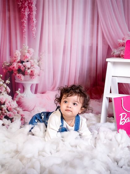 Pretty in pink and sparkling with joy. This little girl is exploring the dreamy, cloud-filled set of her Barbie-themed photoshoot.